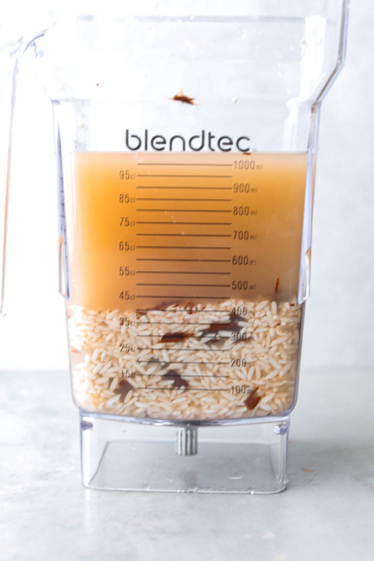 Elevate the flavors of traditional horchata with this strawberry horchata recipe! It's a creamy drink soaked in rice water and cinnamon sticks, then sweetened with a strawberry puree. Everyone loves the strawberry version of this rich, milky Mexican drink! Process photo of the rice water mixture added to a blender.