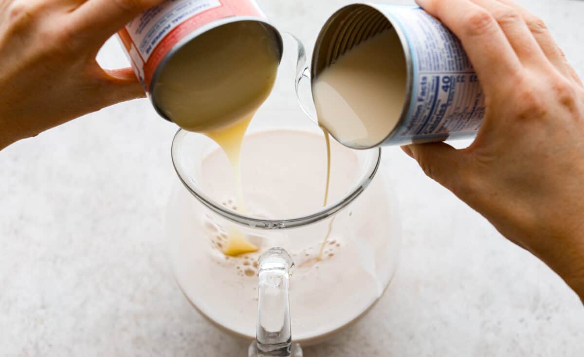 Elevate the flavors of traditional horchata with this strawberry horchata recipe! It's a creamy drink soaked in rice water and cinnamon sticks, then sweetened with a strawberry puree. Everyone loves the strawberry version of this rich, milky Mexican drink! Process photo of the evaporated milk and sweetened condensed milk pouring into the strained rice mixture.
