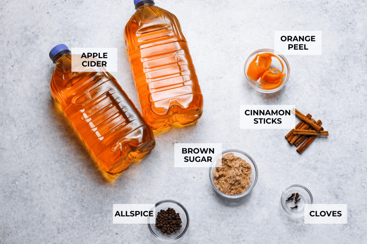Mulled cider is a warm, inviting drink that is mixed with citrus and spices. Take your apple cider game up a notch with this easy recipe. Your house will smell amazing as well! Overhead shot of labeled ingredients.