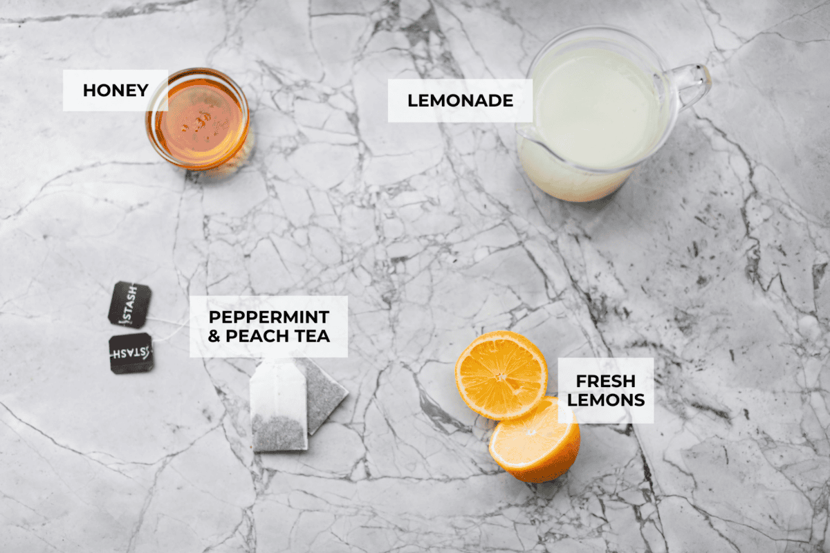 Whenever I am sick, the Starbucks Medicine Ball is my go-to, and this homemade version is even better! Perfect for cold and flu season, this warm drink made of lemonade, honey, and tea is soothing and delicious! Overhead shot of labeled ingredients.